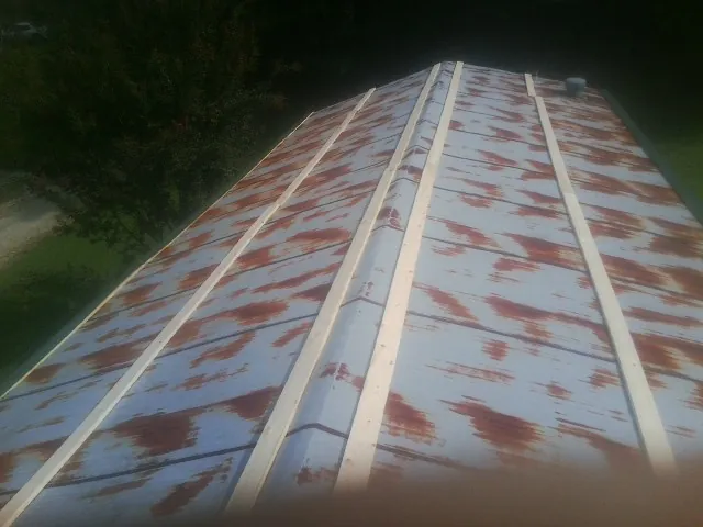 Rusted metal roof panels with new wood purlins before replacement — Storm Damage Roof Repair in Arrington by Roofing Brothers