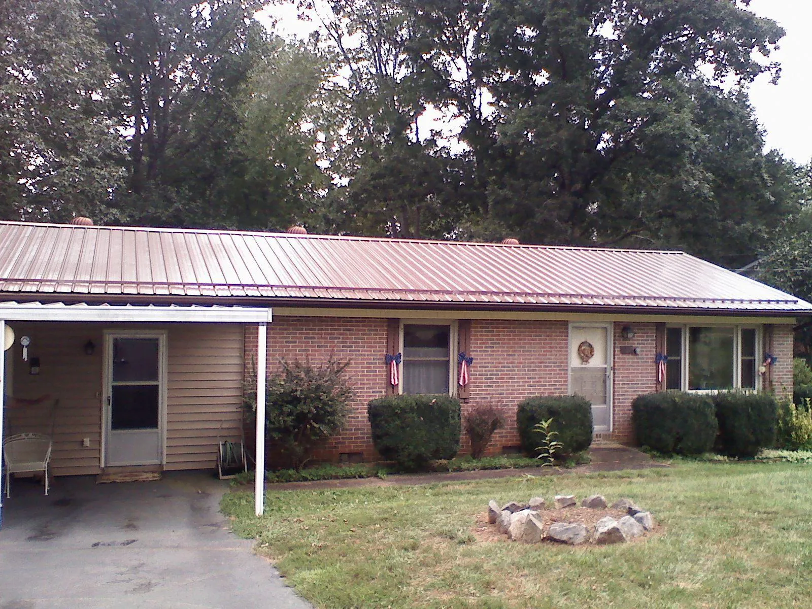 Bronze metal roof and carport on a brick ranch home — Roof Repair work by our crew in Arrington